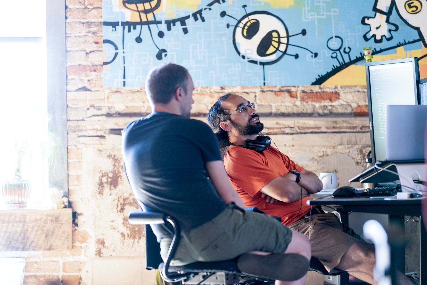 Casual office discussion with creative mural