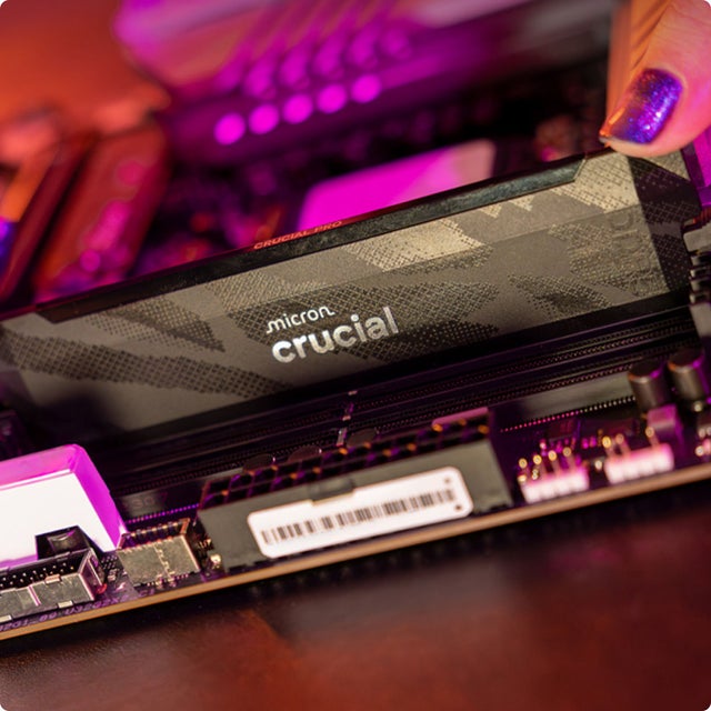 A black Crucial Pro DDR5-6400 resting on top of a motherboard with additional Crucial DRAMs installed.